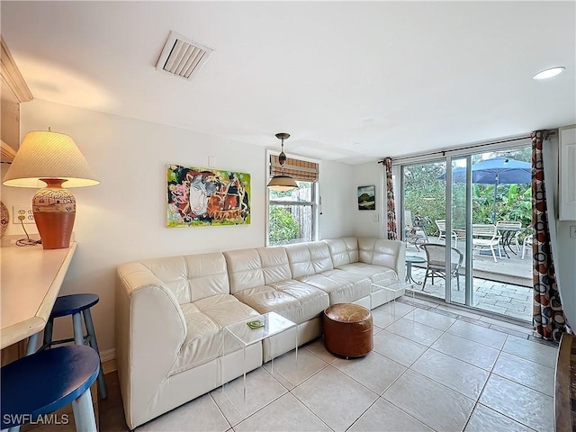 living area featuring visible vents and light tile patterned flooring