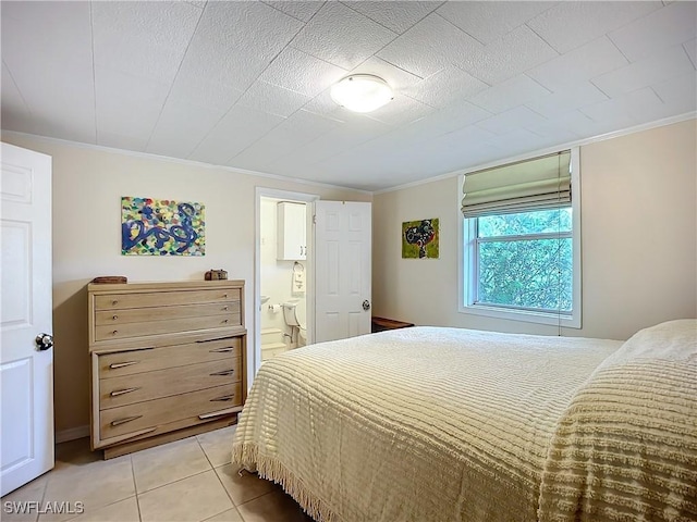 bedroom with light tile patterned floors, ornamental molding, and connected bathroom