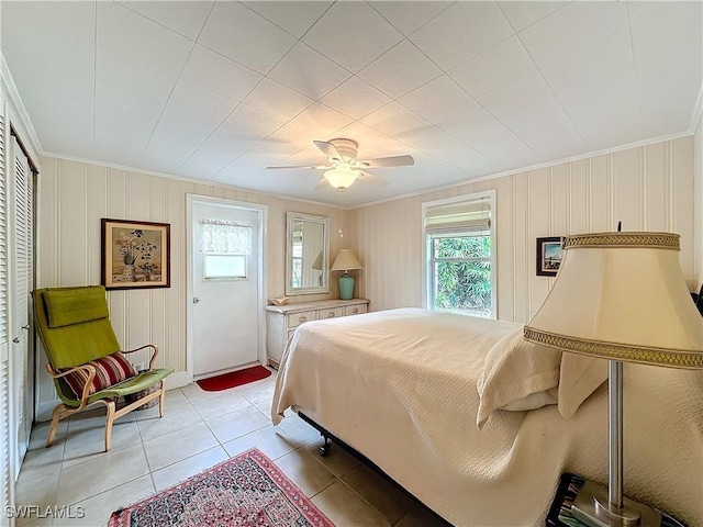 bedroom featuring light tile patterned flooring, crown molding, and ceiling fan