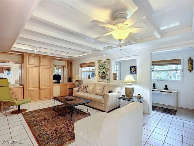 living area featuring light tile patterned floors, beamed ceiling, and a ceiling fan