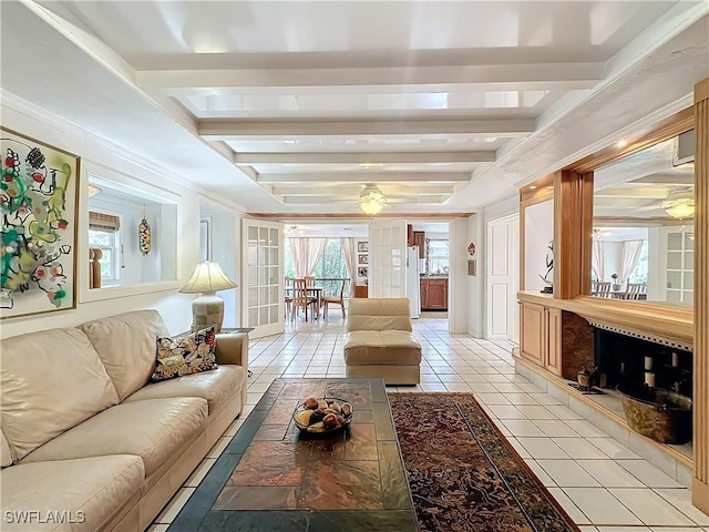 interior space with ceiling fan, a premium fireplace, and beam ceiling