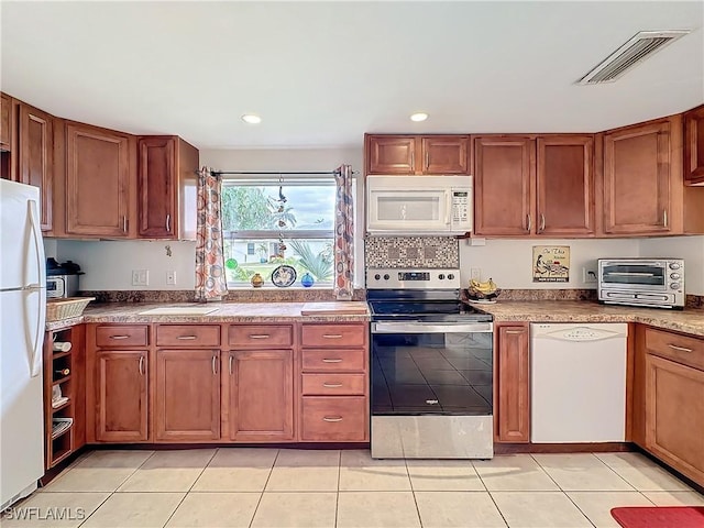 kitchen with brown cabinets, white appliances, visible vents, and a toaster