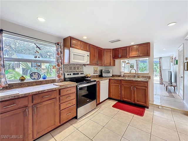 kitchen with white appliances, recessed lighting, a sink, and tasteful backsplash