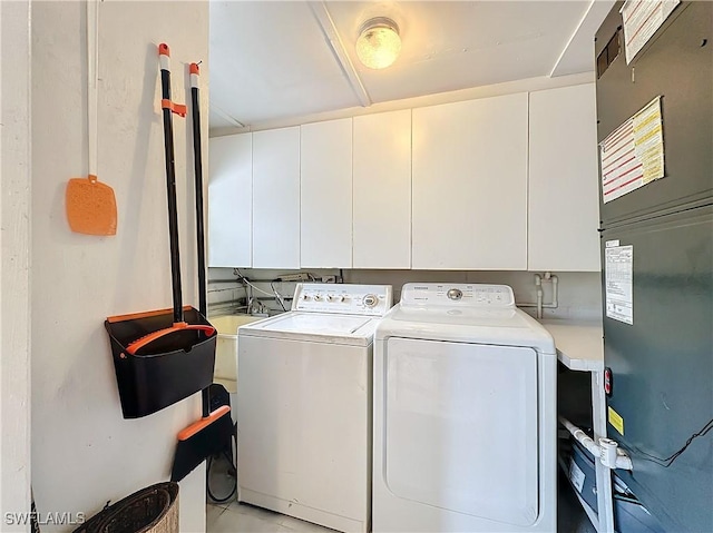 clothes washing area with washer and dryer and cabinet space