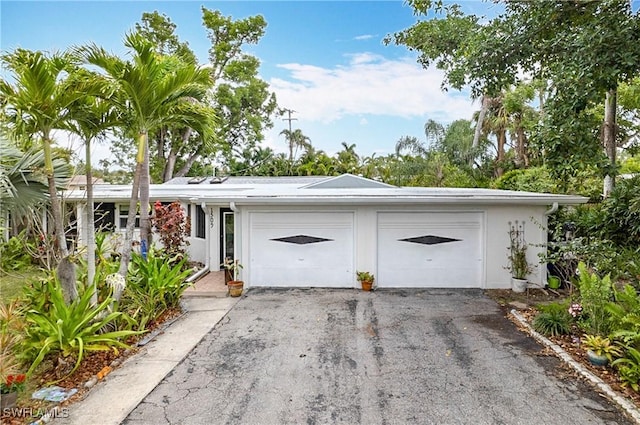 view of front of home featuring an attached garage, aphalt driveway, and stucco siding