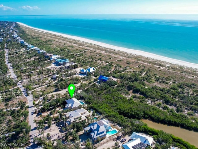 birds eye view of property with a water view and a view of the beach