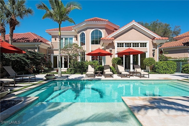 rear view of house featuring a balcony and a patio area