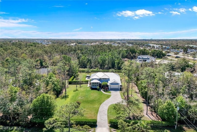 birds eye view of property featuring a view of trees