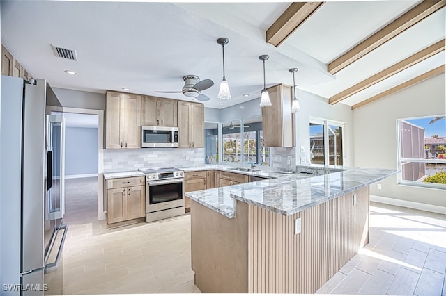 kitchen with decorative light fixtures, stainless steel appliances, light brown cabinetry, and kitchen peninsula