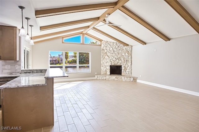 unfurnished living room with a fireplace, beam ceiling, light hardwood / wood-style flooring, ceiling fan, and high vaulted ceiling