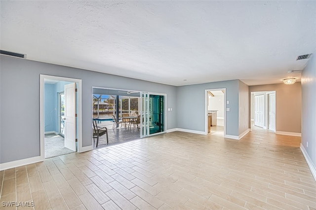 spare room featuring light hardwood / wood-style flooring and a textured ceiling