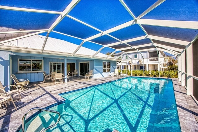 view of swimming pool featuring a patio and a lanai