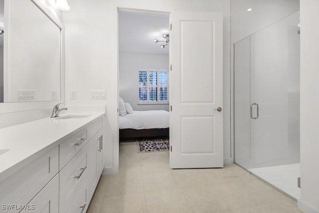 bathroom featuring tile patterned floors, a shower with door, and vanity