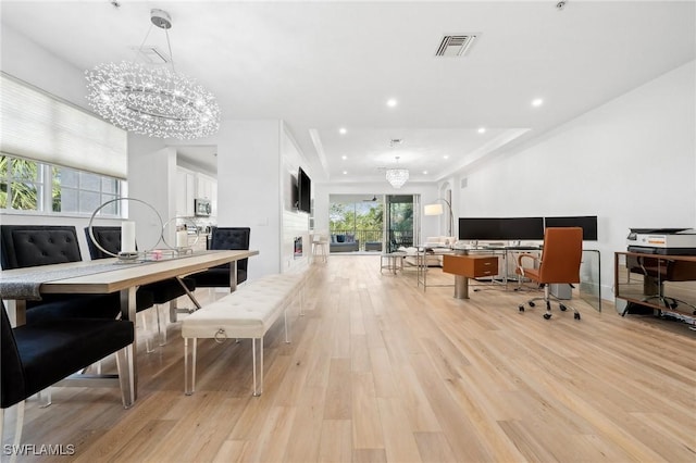 dining area with a chandelier and light hardwood / wood-style flooring