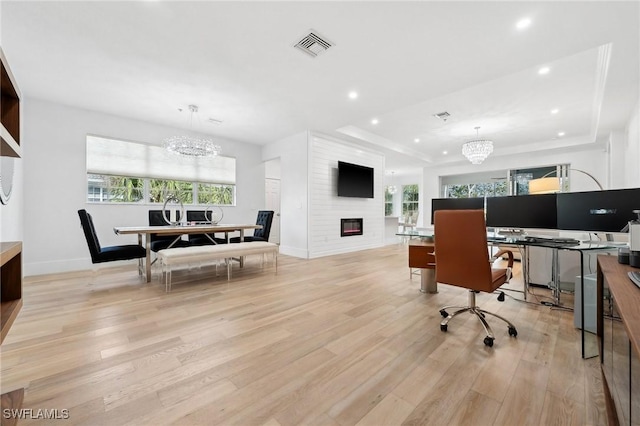 office featuring a healthy amount of sunlight, a notable chandelier, and light wood-type flooring