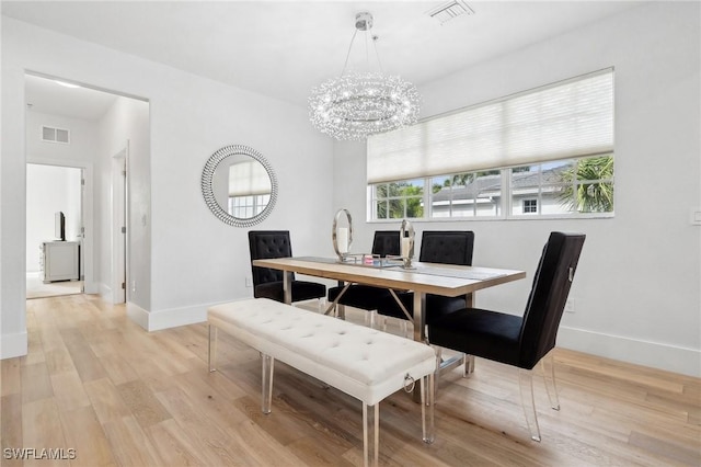 dining room with an inviting chandelier and light hardwood / wood-style floors