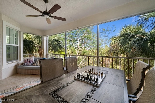 sunroom featuring ceiling fan and plenty of natural light