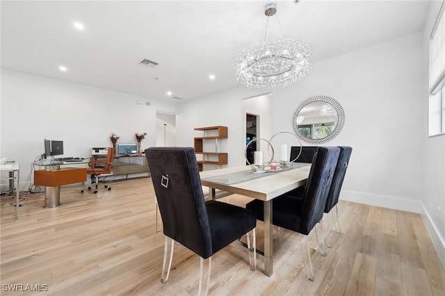 dining area featuring light hardwood / wood-style flooring and a notable chandelier