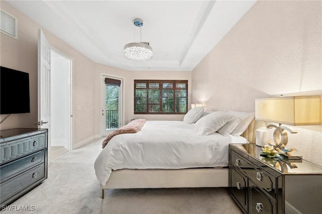 carpeted bedroom with a raised ceiling, a chandelier, and access to outside