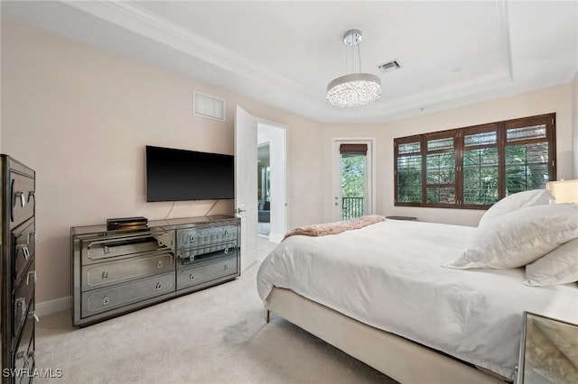 carpeted bedroom with a tray ceiling, access to exterior, and a notable chandelier