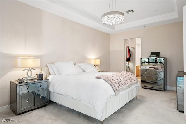 carpeted bedroom featuring a spacious closet, crown molding, a chandelier, and a raised ceiling