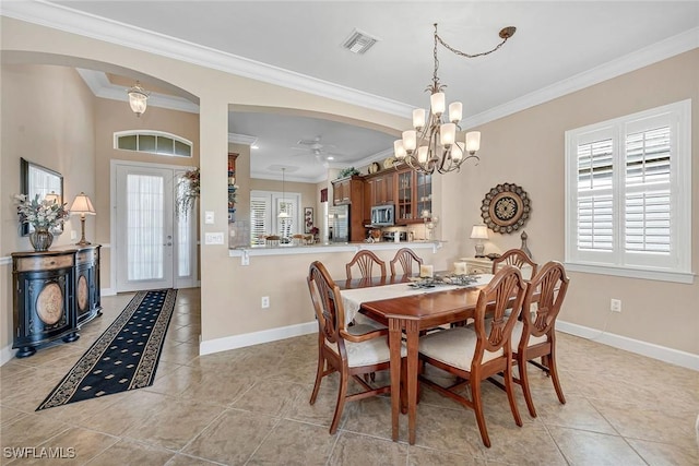 dining space with ornamental molding, arched walkways, a healthy amount of sunlight, and visible vents