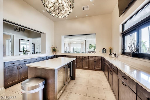 kitchen featuring light tile patterned floors, light countertops, a sink, and a center island