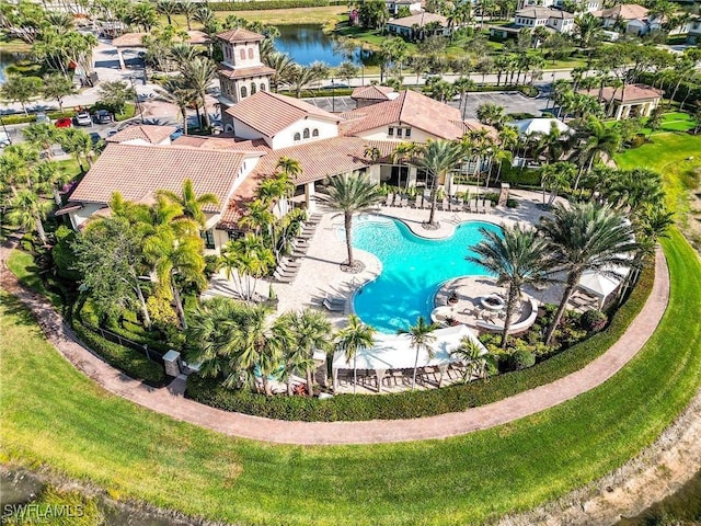 view of swimming pool with a water view, a patio, and a yard