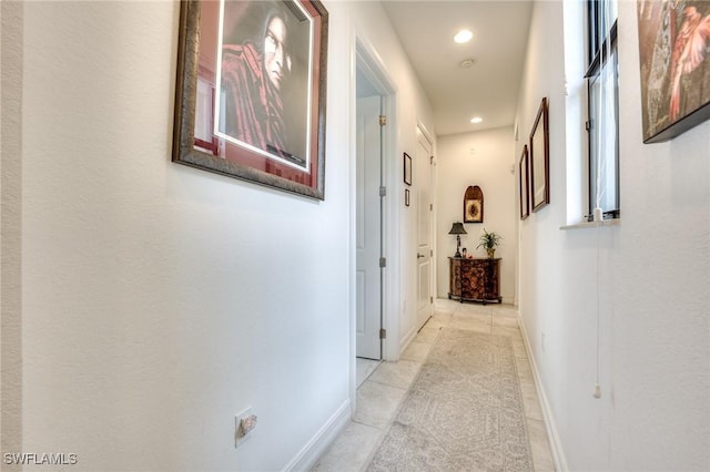 hallway with recessed lighting, baseboards, and light tile patterned floors