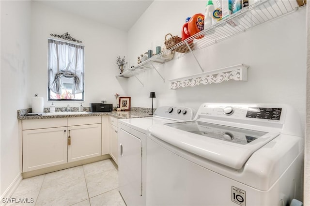 clothes washing area with a sink, washer and clothes dryer, and light tile patterned floors