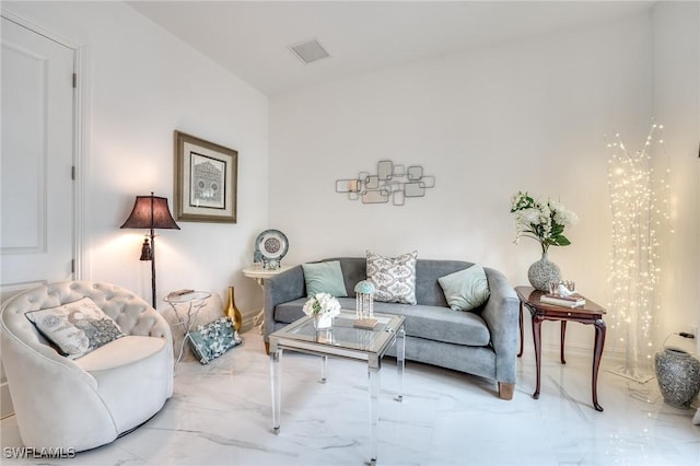 living area featuring marble finish floor and visible vents