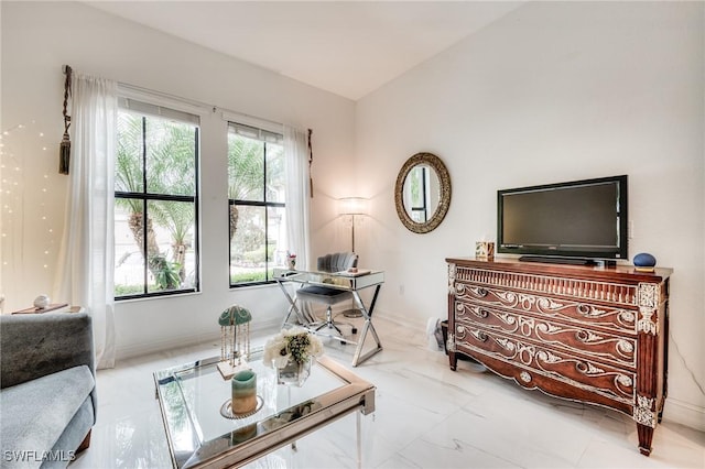 sitting room with marble finish floor, vaulted ceiling, and baseboards