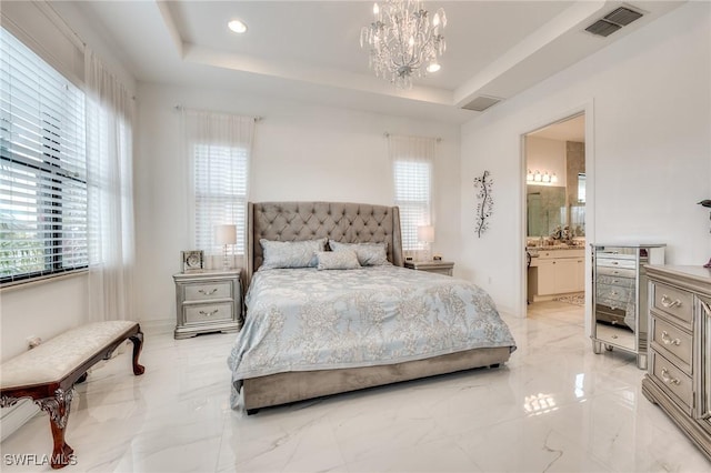 bedroom featuring ensuite bath, an inviting chandelier, visible vents, and a tray ceiling