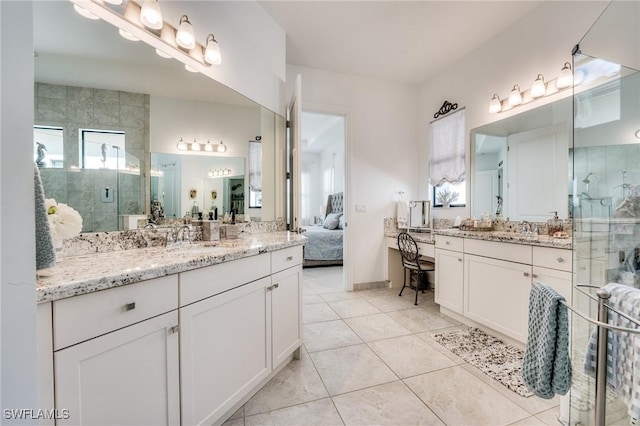 ensuite bathroom with two vanities, connected bathroom, a sink, a shower stall, and tile patterned flooring