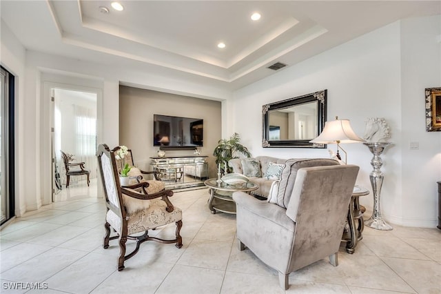 living room with light tile patterned flooring, recessed lighting, visible vents, baseboards, and a raised ceiling