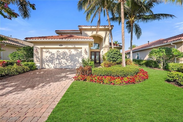 mediterranean / spanish-style house featuring a front yard, french doors, and a garage