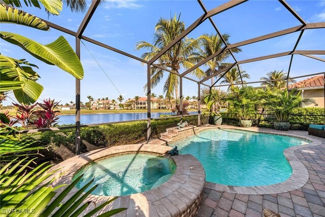 view of pool with a patio area, a water view, an in ground hot tub, and glass enclosure