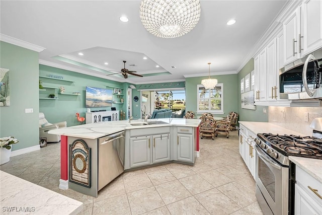 kitchen featuring decorative light fixtures, appliances with stainless steel finishes, white cabinetry, and sink