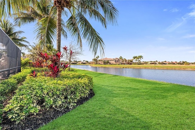 view of yard featuring a water view and glass enclosure