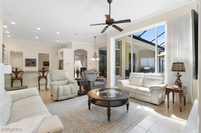 living room with light tile patterned floors, arched walkways, recessed lighting, ceiling fan with notable chandelier, and crown molding