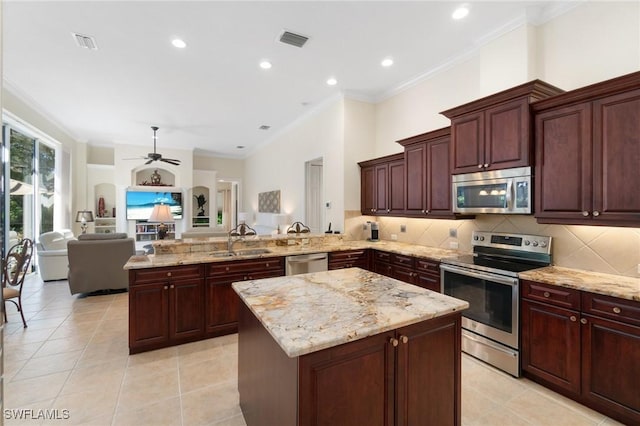 kitchen with visible vents, appliances with stainless steel finishes, a center island, a peninsula, and a sink