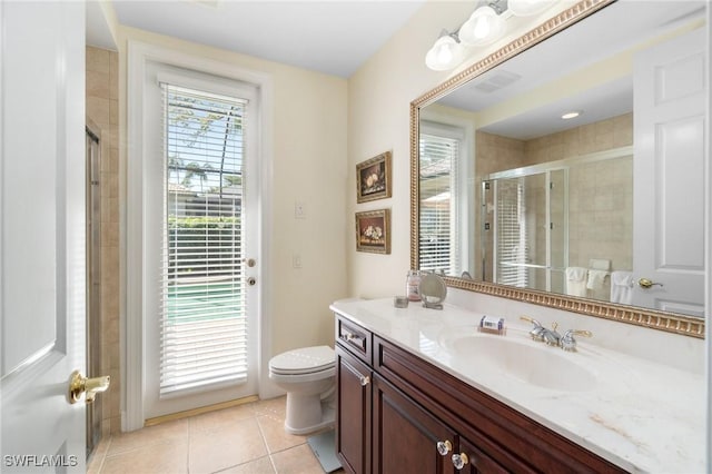 bathroom with toilet, visible vents, vanity, tile patterned floors, and a stall shower