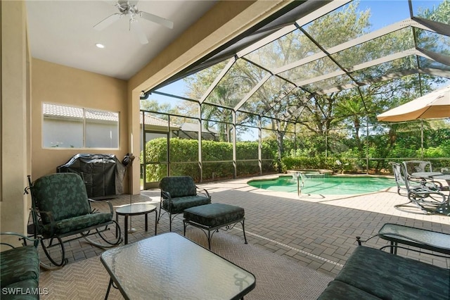 view of pool with area for grilling, a patio, ceiling fan, a lanai, and a pool with connected hot tub