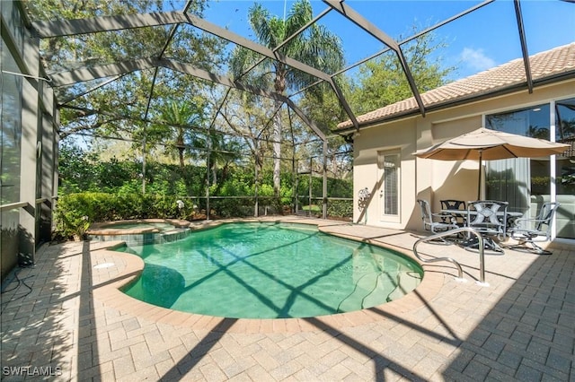 view of swimming pool with a patio area, a pool with connected hot tub, and glass enclosure