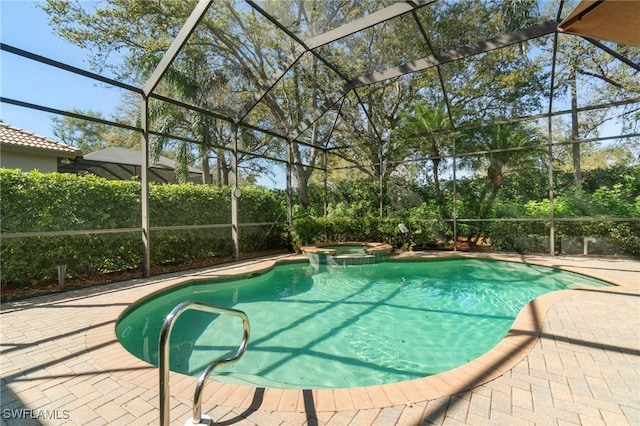 view of pool featuring glass enclosure, a pool with connected hot tub, and a patio