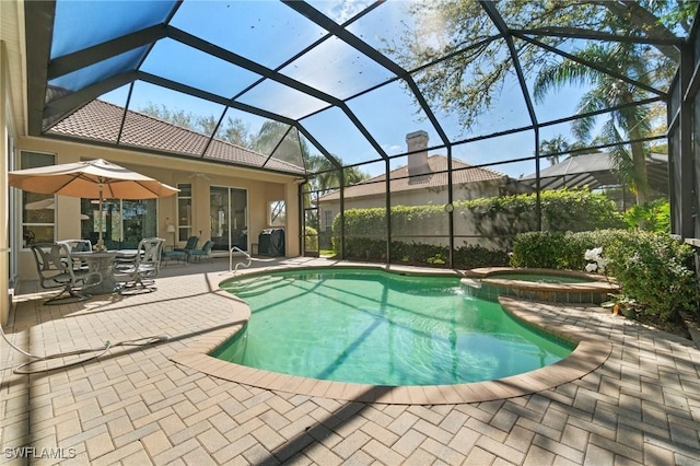 view of swimming pool with a patio area, a lanai, a pool with connected hot tub, and a ceiling fan