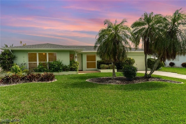 ranch-style home with driveway, a garage, a front lawn, and stucco siding