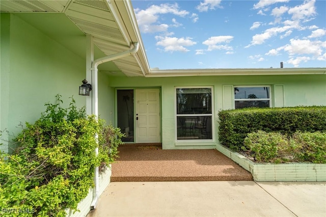 view of exterior entry with stucco siding