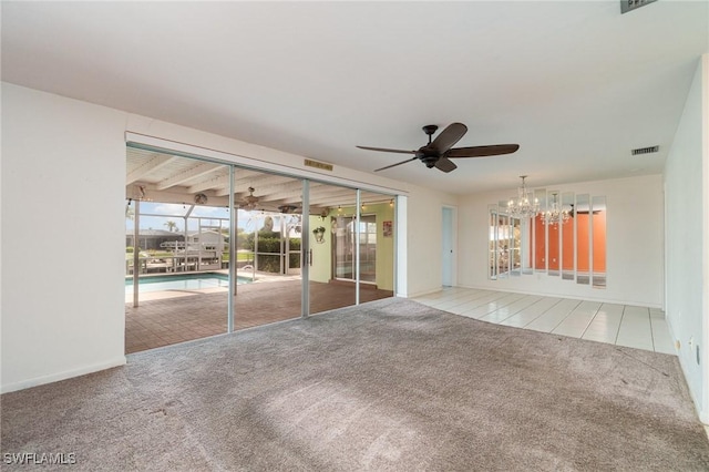 empty room with carpet, visible vents, and ceiling fan with notable chandelier