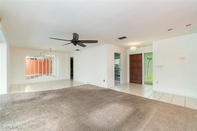 empty room featuring ceiling fan with notable chandelier, light tile patterned flooring, visible vents, and light colored carpet